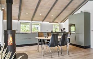 a kitchen with a table and chairs and a fireplace at Amazing Home In Hvide Sande With Wifi in Bjerregård