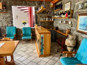 a restaurant with blue chairs and a counter in a room at Villa del sole in Magomadas +24 photos