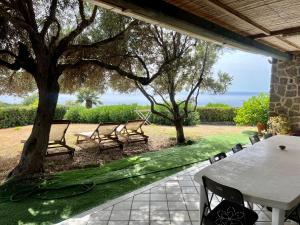 a patio with a table and chairs and a tree at Villa del sole in Magomadas