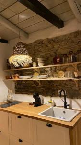 a kitchen with a sink and a stone wall at Olive Tree House in Terena
