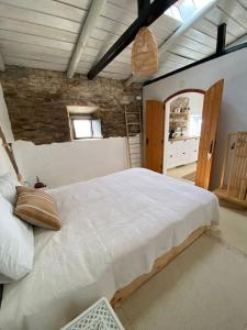 una camera da letto con un grande letto bianco in una stanza di Olive Tree House a Terena