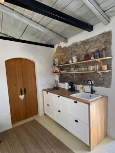a kitchen with a sink and a wooden door at Olive Tree House in Terena +21 photos