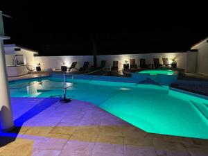 a swimming pool at night with blue lighting at Villa Sany:10 Pers Maison 200m2 piscine , jacuzzi in Narrosse