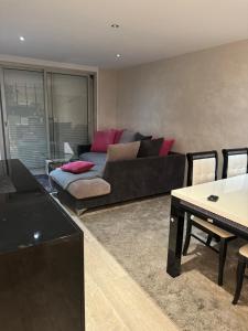 ein Wohnzimmer mit Sofa und Tisch in der Unterkunft 3p cosy vue mer in Nizza