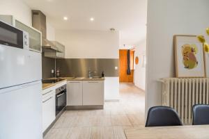 a kitchen with white appliances and a table and chairs at Maison Confortable au coeur de Guingamp in Guingamp +6 photos