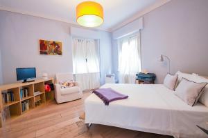 a bedroom with a large white bed and a chair at Belle Viste - Boutique Apartments in Bettolle