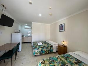 莫里iGrand Motel的客房设有两张床、一张桌子和一台冰箱