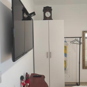 two white cabinets with a clock on top of them at הבית קרוב לחוף in Ashkelon