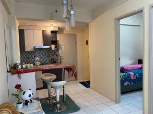 a kitchen with a counter and a room with a bed at Apartemen Center Point Bekasi in Kayuringin