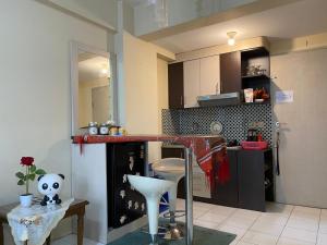 a kitchen with a counter and a table in a room at Apartemen Center Point Bekasi in Kayuringin