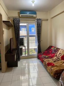 a bedroom with a bed and a large window at Apartemen Center Point Bekasi in Kayuringin