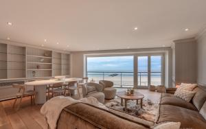 a living room with a couch and a table at 3e verdiep 3-slaapkamer appartement op de zeedijk in hartje Knokke voor 7 personen in Knokke-Heist