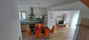 a kitchen and dining room with a table and chairs at Garden Baltic in Trzęsacz