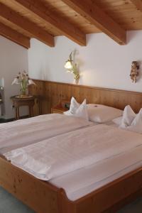 a bedroom with a large bed with white sheets at Kurhotel Rupertus in Bad Reichenhall