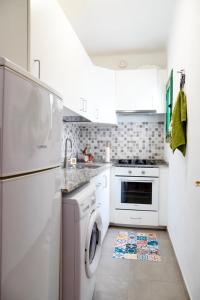 a white kitchen with a washer and dryer at apartamento famara 4 in Famara
