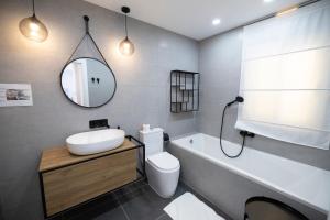 un bagno con lavandino, water e specchio di Terraced Penthouse with Views and Jacuzzi a Xagħra