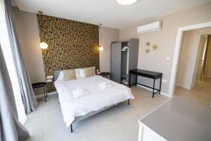 una camera con un letto bianco e un tavolo nero di Terraced Penthouse with Views and Jacuzzi a Xagħra