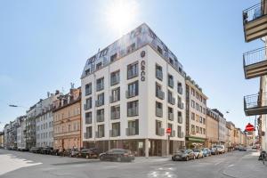 a tall white building on a city street with cars at Nena Apartments München City in Munich