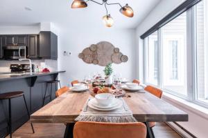 a kitchen and dining room with a wooden table at L'Érablière Tremblant Ski Inout Condo W 2bdrs in Mont-Tremblant