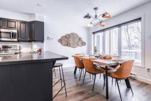 a kitchen and dining room with a table and chairs at L'Érablière Tremblant Ski Inout Condo W 2bdrs in Mont-Tremblant