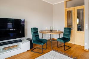 a dining room with a table and chairs and a television at Luxuriöse Wohnung mit Terrasse, Balkon und Wasserbett - 24h Check-In in Garbsen