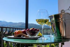 a table with two glasses of wine and a bowl of fruit at Casa de Clarisse in Ermelo