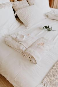 a white bed with white sheets and flowers on it at Suite de charme avec jacuzzi et cabine infrarouge in Tubize