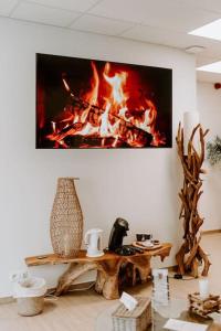 a living room with a fire painting on the wall at Suite de charme avec jacuzzi et cabine infrarouge in Tubize +1 photo