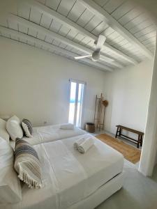 ein weißes Schlafzimmer mit einem großen Bett und einem Deckenventilator in der Unterkunft Casa Ponente in Istérnia