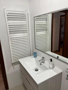 a white bathroom with a sink and a mirror at Casablanca 95 in Vigo