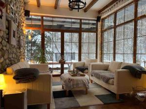 a living room with white furniture and large windows at Snow White Chalet in Brezovicë