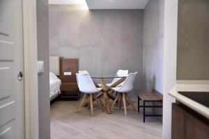 a dining room with a table and white chairs at La Maison Latina Guest House in Latina