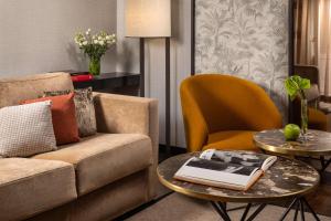 a living room with a couch and a table with a book on it at NH Collection Madrid Palacio de Tepa in Madrid