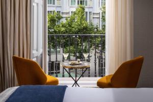 a room with a table and two chairs and a window at NH Collection Madrid Palacio de Tepa in Madrid