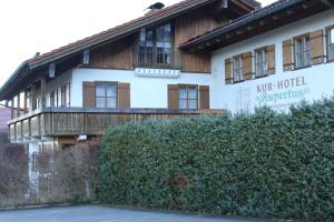 a large white building with a wooden balcony at Kurhotel Rupertus in Bad Reichenhall