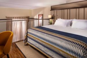 a hotel room with a bed and a chair at NH Collection Madrid Palacio de Tepa in Madrid