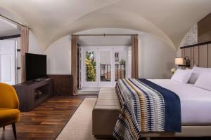 a hotel room with a bed and a television at NH Collection Madrid Palacio de Tepa in Madrid