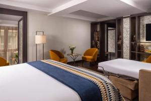 a hotel room with a bed and chairs at NH Collection Madrid Palacio de Tepa in Madrid