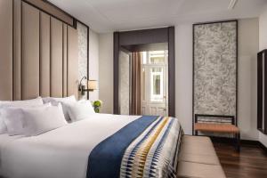 a bedroom with a large white bed and a window at NH Collection Madrid Palacio de Tepa in Madrid