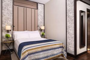 a hotel room with a bed and a mirror at NH Collection Madrid Palacio de Tepa in Madrid