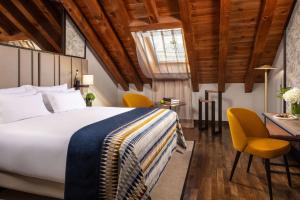 a bedroom with a bed and a table and chairs at NH Collection Madrid Palacio de Tepa in Madrid