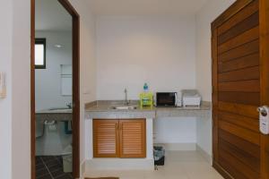 a kitchen with a sink and a microwave on a counter at Kataonsea bungalows in Kata Beach +81 photos
