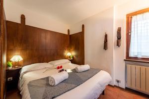 a hotel room with two beds with towels and a window at Flat with Garden in Courmayeur - Happy Rentals in Courmayeur