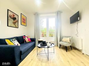 a living room with a blue couch and a table at PopLaon appartement avec terrasse in Laon