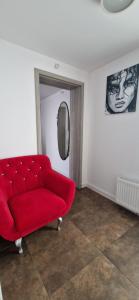 salon z czerwoną kanapą i lustrem w obiekcie Apartamenty Orchidea Łeba w Łebie +8 zdjęć