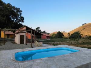 una piscina blu davanti a una casa di Chalés Jatobá ad Areias