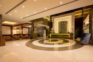 a lobby with a reception desk in a building at Golden Tulip Media Hotel in Dubai +48 photos
