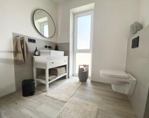 a bathroom with a sink and a toilet and a mirror at Oh my Deer nagelneues Appartement für Zwei in Tauberbischofsheim
