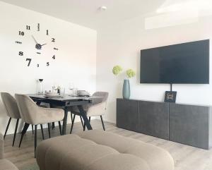 a dining room with a table and a clock on the wall at Oh my Deer nagelneues Appartement für Zwei in Tauberbischofsheim