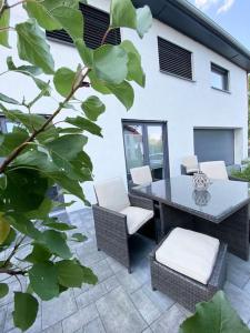 a patio with a table and chairs and a building at Oh my Deer nagelneues Appartement für Zwei in Tauberbischofsheim
